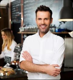 Restaurant owner smiling at counter